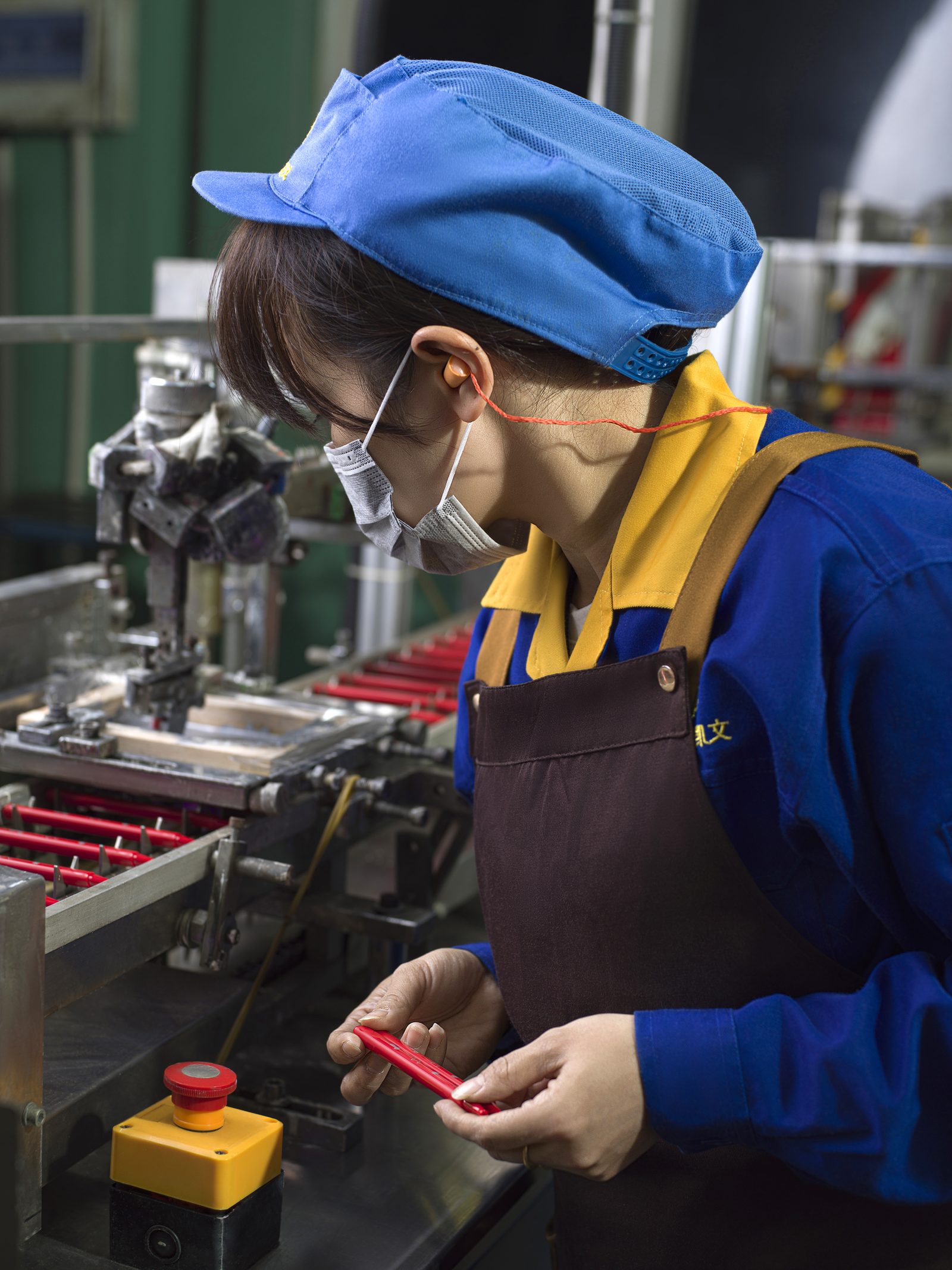 Kaywin worker inspecting polypropylene marker barrels on the production line